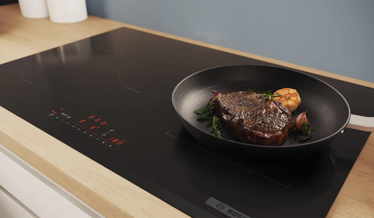 Pan cooking steak on induction hob